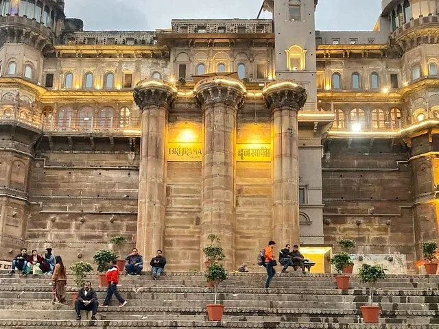 Menschen sitzen auf den Stufen vor dem prächtigen BrijRama Palace.