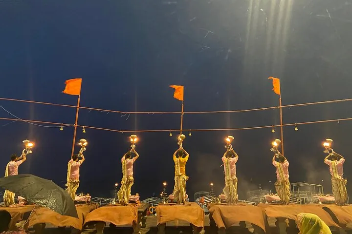 Priester mit brennenden Lampen während einer abendlichen Ganga-Aarti in Varanasi.